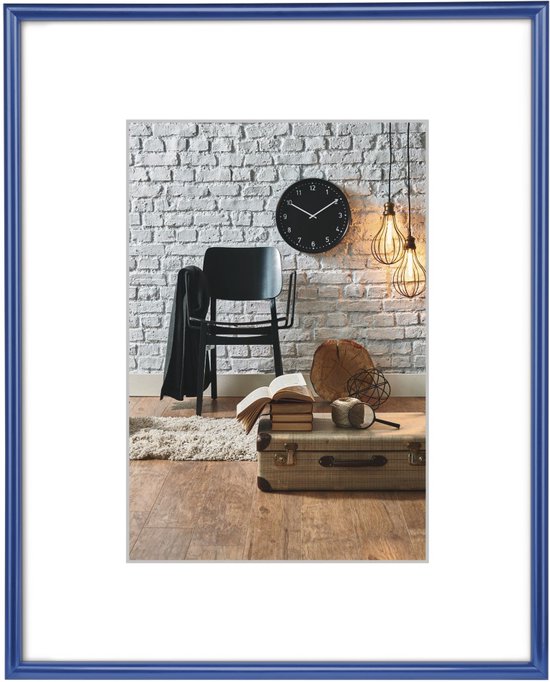 Cadre photo bleu avec passe-partout blanc, posé sur un plancher en bois.