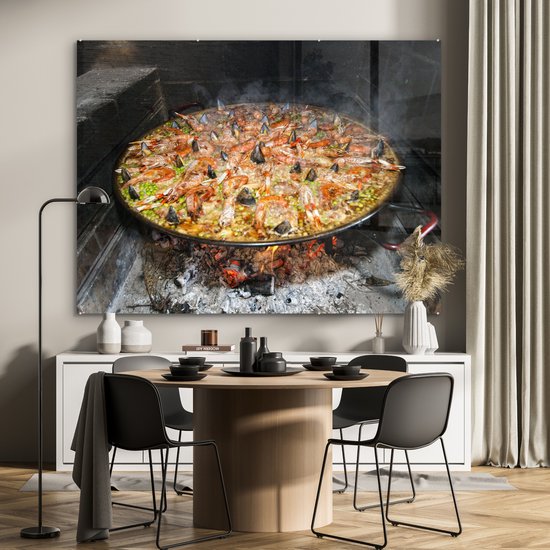 MuchoWow® Glasschilderij 160x120 cm - Schilderij acrylglas - Zeevruchtenrijst gekookt in een brandhou. Paella is een van de traditionele gerechten van Spanje - Foto op glas - Schilderijen