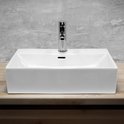 Lavabo rectangulaire en céramique blanche avec un robinet chromé, posé sur un plan de travail en bois.