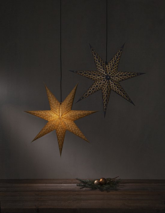 Deux étoiles de Noël en papier, une dorée et une noire avec des détails dorés, suspendues au-dessus d'une table en bois.