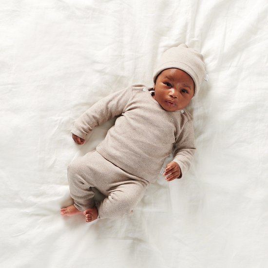 Baby in taupe melange outfit van longsleeve en broek met bijpassende muts. Geribde stof.