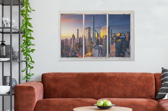 Toile avec vue sur la skyline de New York au coucher du soleil, accrochée au-dessus d'un canapé brun orangé.