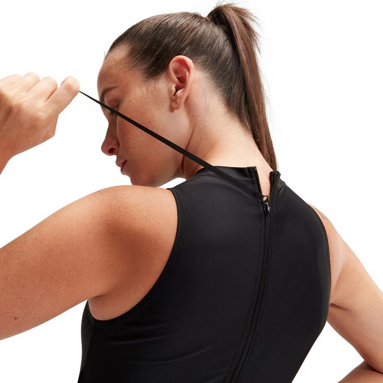Close-up van de rug van een vrouw in zwart Speedo badpak met rits.