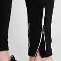 Close-up van de enkel van een zwarte Karrimor legging met rits en gestreepte details.