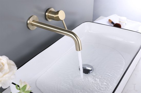 Gouden wandkraan met gebogen uitloop boven een witte wastafel met zwarte rand.