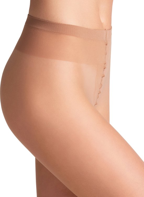 Close-up van de heup van een vrouw, draagt een huidskleurige, transparante panty met een comfortabele tailleband.