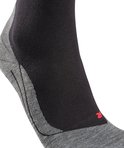 Gros plan d'une chaussette de course Falke, noire avec talon gris et 'R' rouge.