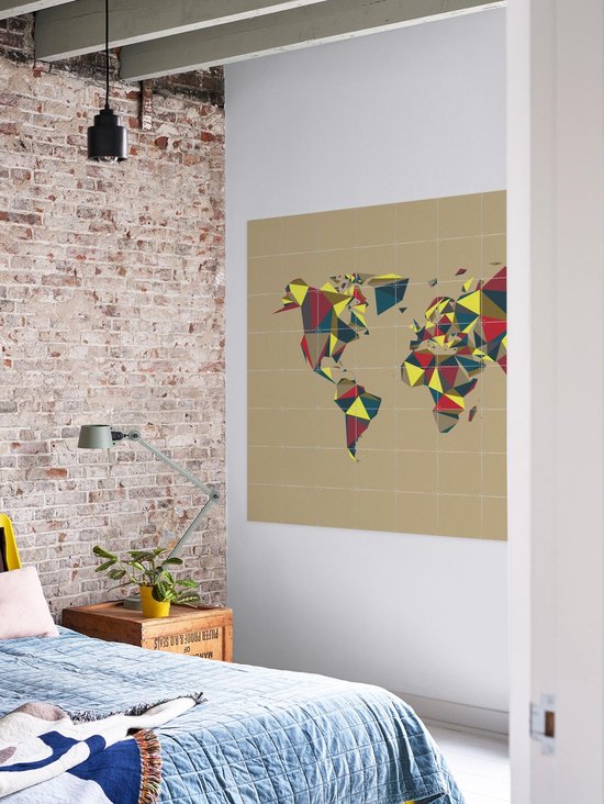 Carte du monde avec des motifs géométriques rouge, jaune et bleu, accrochée au mur dans une chambre à coucher.