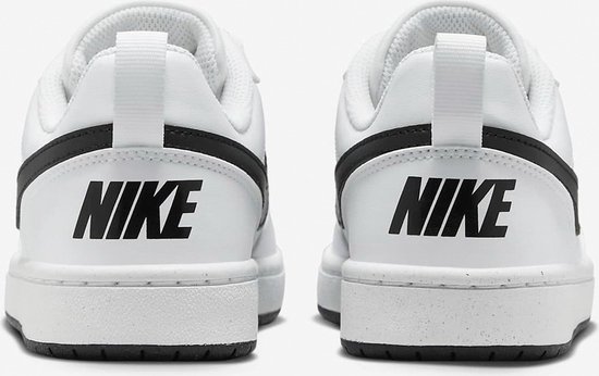 Achterkant van witte Nike sneakers met zwarte opdruk "NIKE" op de hiel.