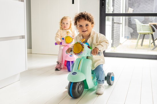 Twee kinderen op VTech 2-in-1 scooters, één mintgroen en één roze, met een zonnige achtergrond.