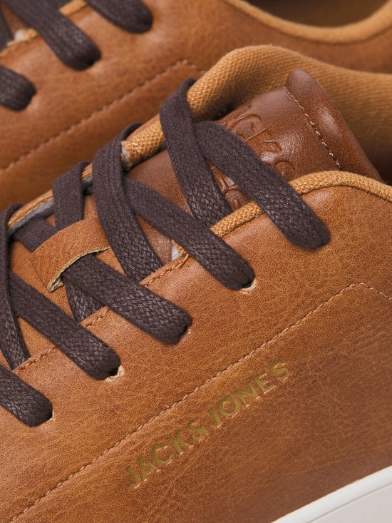 Close-up van bruine leren sneakers van Jack & Jones met donkerbruine veters en goudkleurig logo.