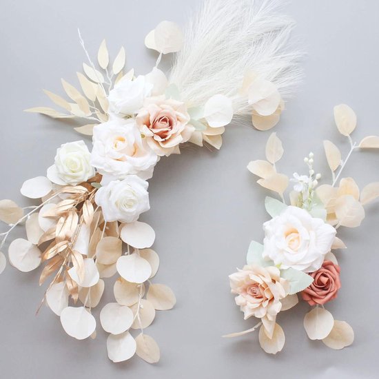 Twee bloemstukken met witte, crèmekleurige en roze rozen, gouden bladeren en pampasgras op grijze achtergrond.