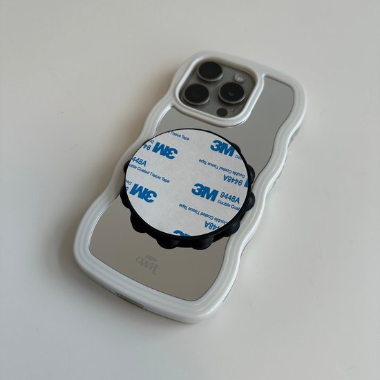 Een telefoonhoesje met de onderkant van een telefoonsticker, bedekt met de beschermfolie.