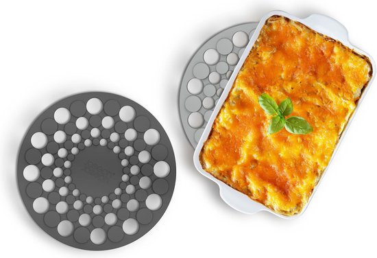 Grijze Joseph Joseph onderzetter naast een ovenschaal met lasagne.