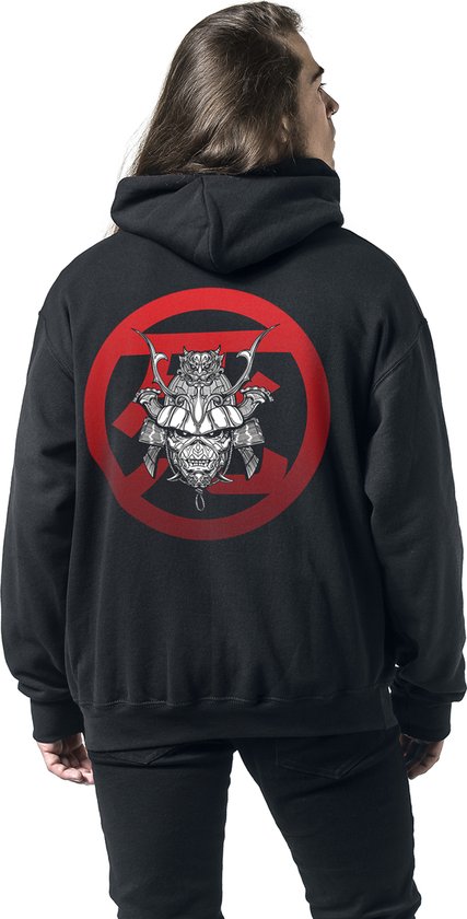 Man met lange haren, achterkant van zwarte hoodie met opdruk samurai-helm in rode cirkel.