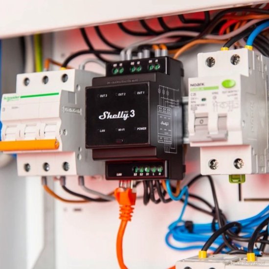 Zwarte Shelly Pro 3 DIN-railrelais met oranje LAN-kabel aangesloten in een schakelkast.