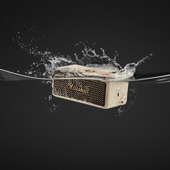 Crème Marshall speaker die in water wordt gegooid, spat op.