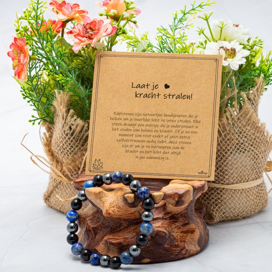 Armband van lapis lazuli, onyx en hematiet kralen naast een geschenkenkaart en bloemen.