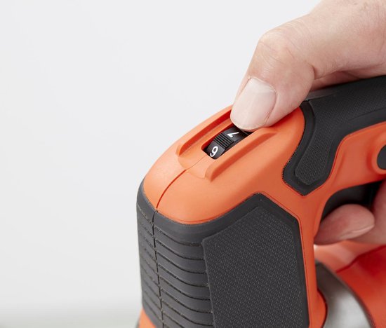 Vinger past de snelheidsinstelling '7' aan op de oranje Black+Decker decoupeerzaag.