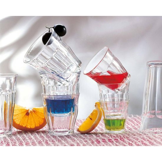 Verres empilés avec des boissons bleues et rouges, des tranches d'orange et un raisin.