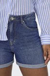 Model draagt denim shorts met opgerolde zoom.