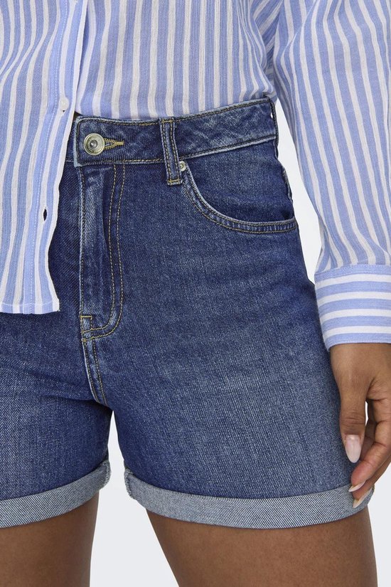 Model draagt denim shorts met opgerolde zoom.