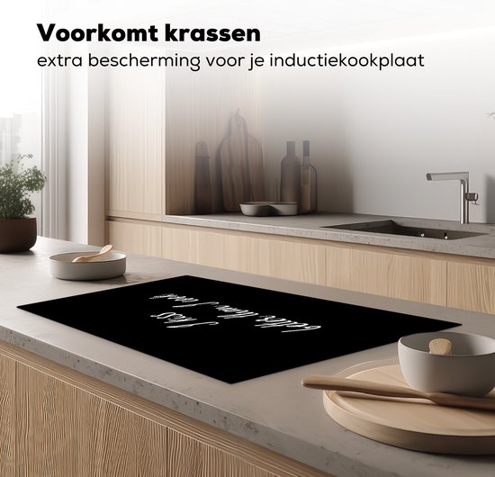 Zwarte inductiebeschermer met tekst 'I kiss better than I cook' in een moderne keuken.