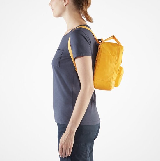 Vrouw draagt een gele Kånken rugzak aan de zijkant.