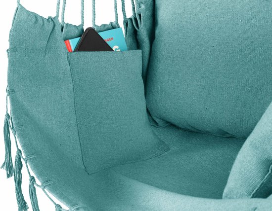 Detail van een turquoise hangstoel met een opgestikte zak met daarin een telefoon en een boekje.