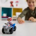 Kind met een Paw Patrol Ryder speelgoedquad met Ryder erop. Blauwe en witte quad met rode accenten.