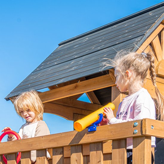 Kinderen met een speelgoedtelescoop en stuurwiel in een houten speelhuisje.