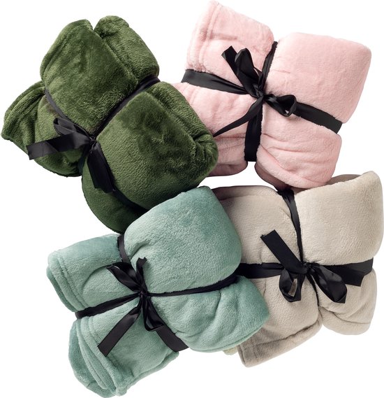 Vier opgerolde dekens in de kleuren groen, lichtroze, mintgroen en beige, elk gebonden met een zwart lint.