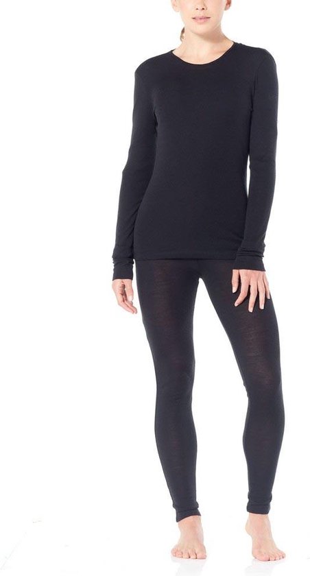 Model in zwart thermoshirt met lange mouwen en zwarte legging.