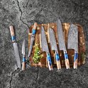 Een set van zes Damastmessensets met blauwe en bruine handvatten, gelegen op een houten snijplank met groenten.