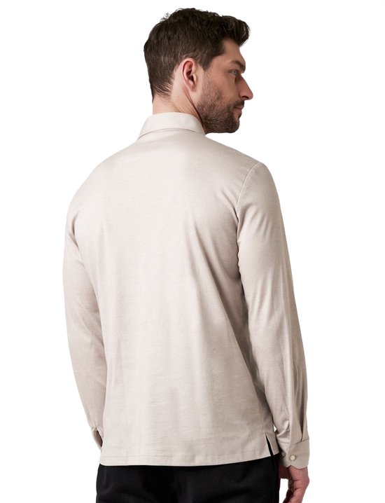 Man met rug naar de camera, draagt beige longsleeve poloshirt.