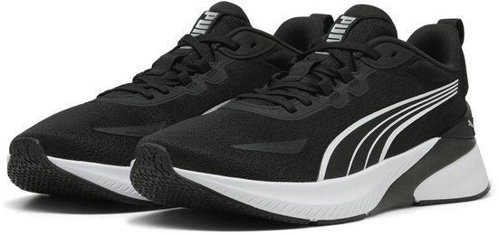 Paire de chaussures de sport PUMA noires avec rayures, lacets et semelles blancs.