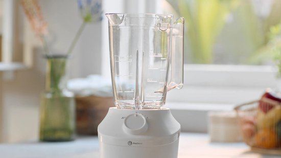 Witte Philips blender met transparante kan, de basis met draaiknop is zichtbaar.