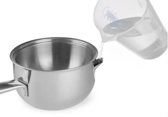 Water wordt uit een glazen maatbeker in een roestvrijstalen steelpan gegoten.