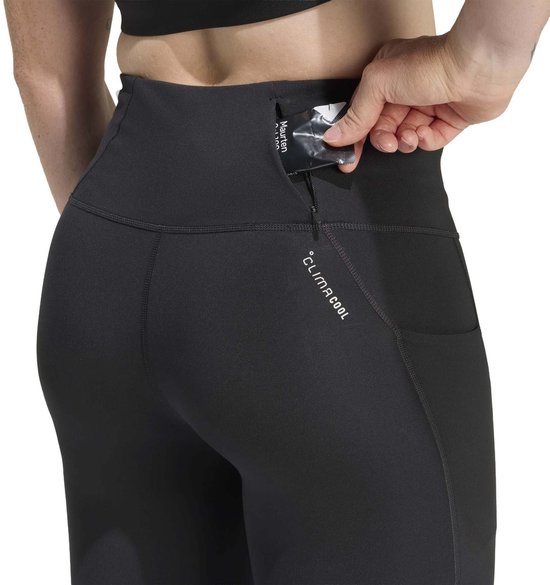 Zwarte dames legging met 'ClimaCool' opdruk en een hand die een telefoon in een zak stopt.