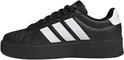 Zijkant van een zwarte damessneaker met platformzool en witte Adidas-strepen.