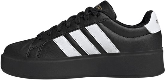 Zijkant van een zwarte damessneaker met platformzool en witte Adidas-strepen.