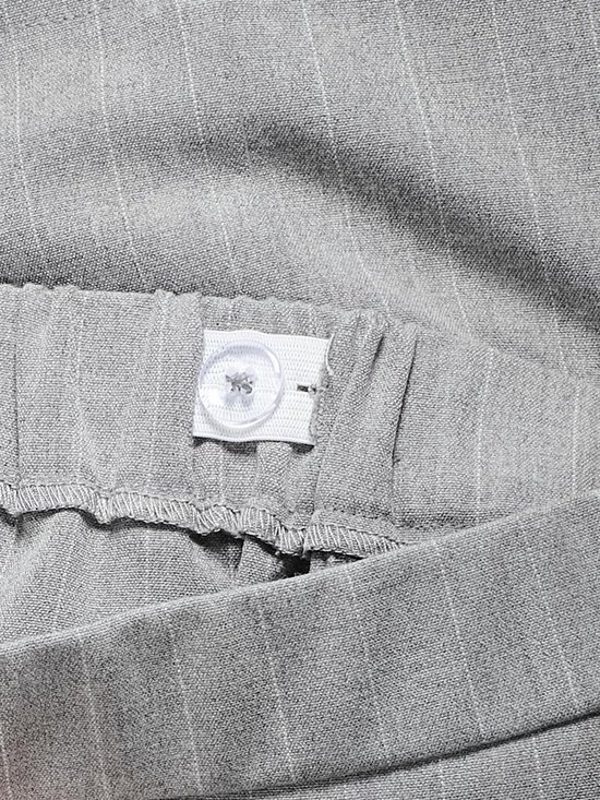 Grijs gestreepte stof met elastische tailleband en knoopsluiting.