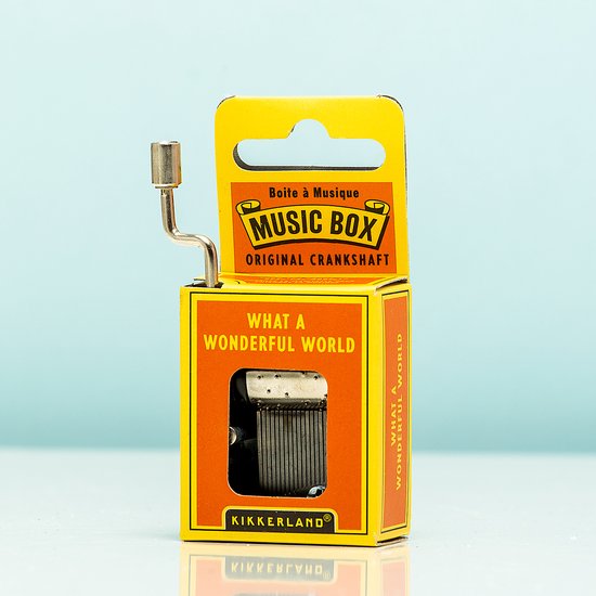 Boîte à musique dans un emballage jaune-orange avec texte 'Music Box' et 'What A Wonderful World'. Avec manivelle.