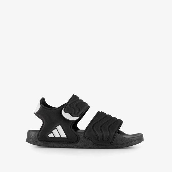 Zwarte Adidas Adilette kindersandaal met golvend patroon, klittenband en drievoudig wit logo.