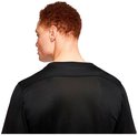 Dos d'un homme aux cheveux roux, portant un t-shirt de sport noir avec un détail en mesh sur les épaules.