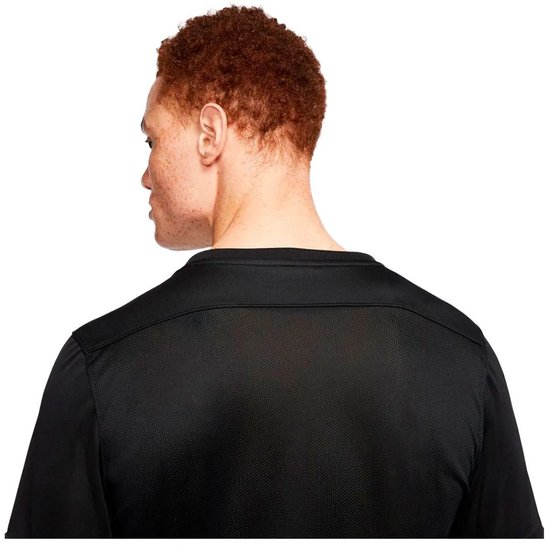 Dos d'un homme aux cheveux roux, portant un t-shirt de sport noir avec un détail en mesh sur les épaules.