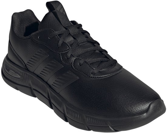 Schuin voorzicht van een zwarte Adidas sneaker met lederlook, vetersluiting en rubberen zool.