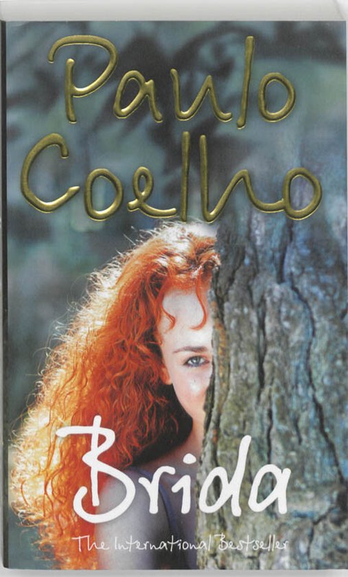 Boekomslag van Brida met gouden letters. Een vrouw met rood haar kijkt achter een boom vandaan.