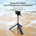 Zwarte en oranje selfiestick als drijvend statief op het strand bij het water.