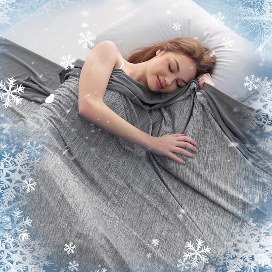 Vrouw slaapt op haar zij onder een zachte, grijze, gemêleerde deken in bed, omringd door sneeuwvlokjes.